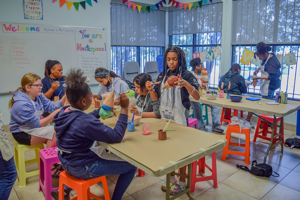Volunteer helping student with art project